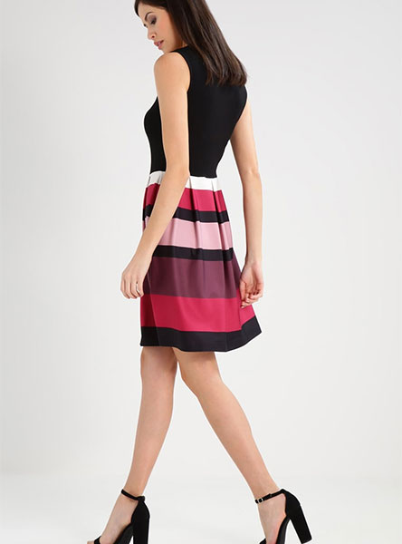 woman in black, brown and red striped dress - side view