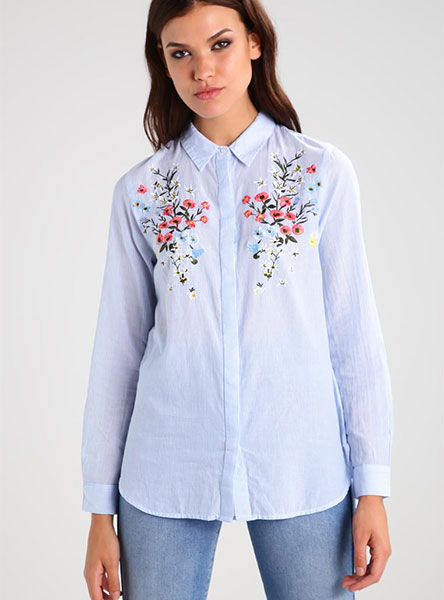 woman in blue shirt embroidered with flowers